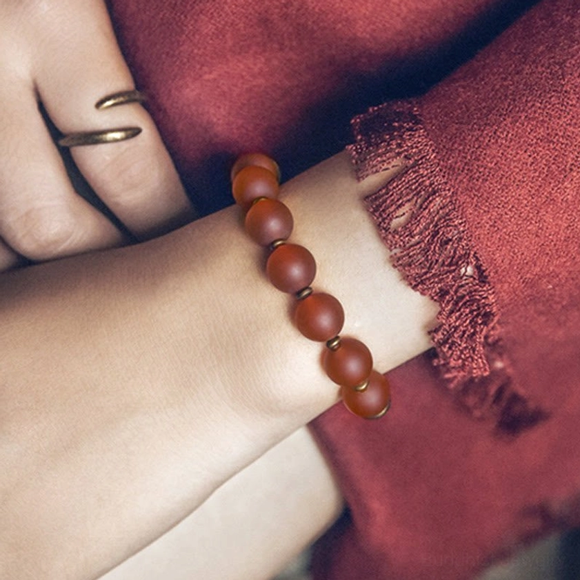 Red agate Buddhist confidence bracelet side view on wrist with matte natural stone finish