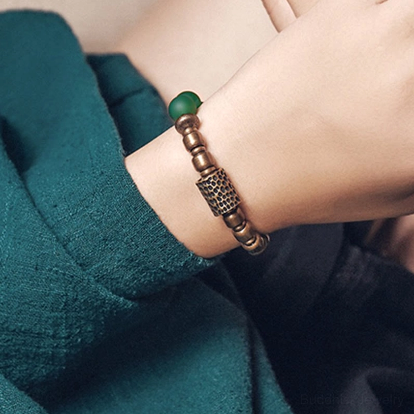 Red agate Buddhist meditation bracelet showing natural stone texture and copper hardware detail