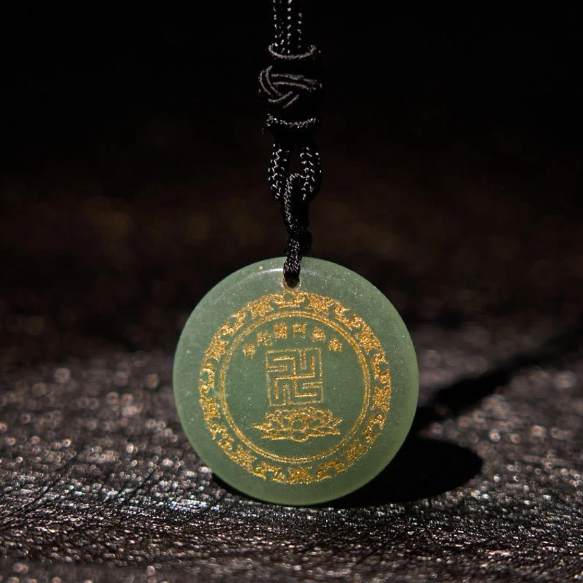 Red agate Buddhist pendant swastika lotus design on dark leather background front view