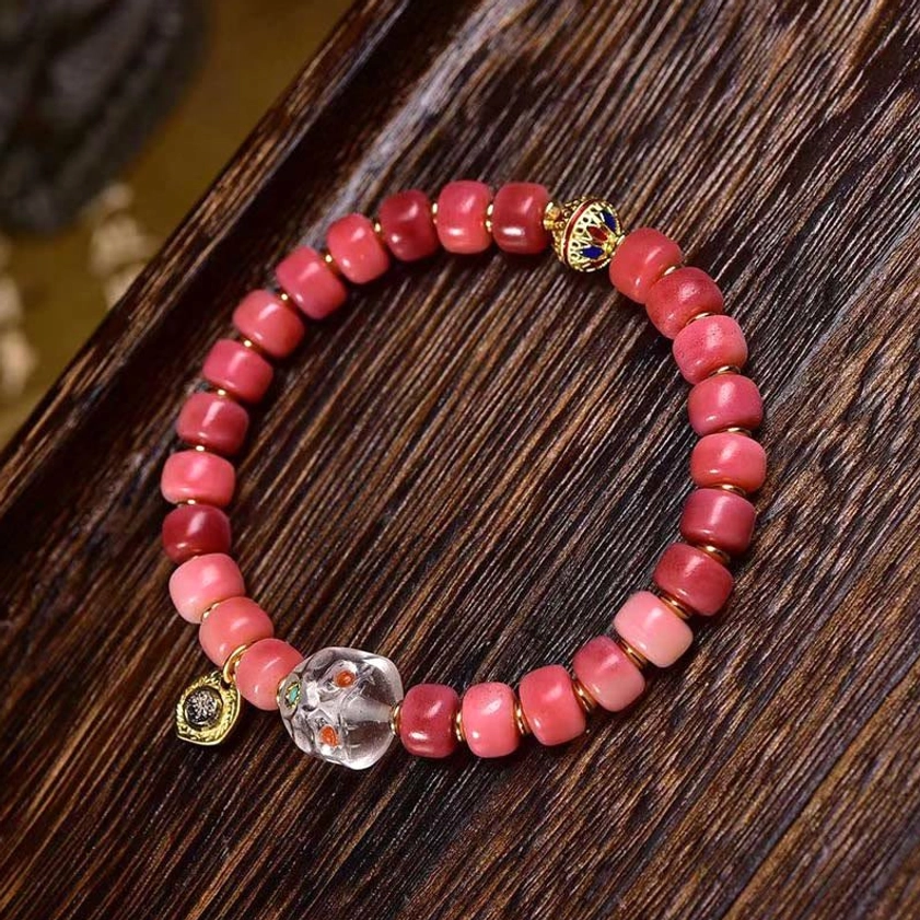 Red agate and camel bone Buddhist bracelet featuring multiple metal charm accents