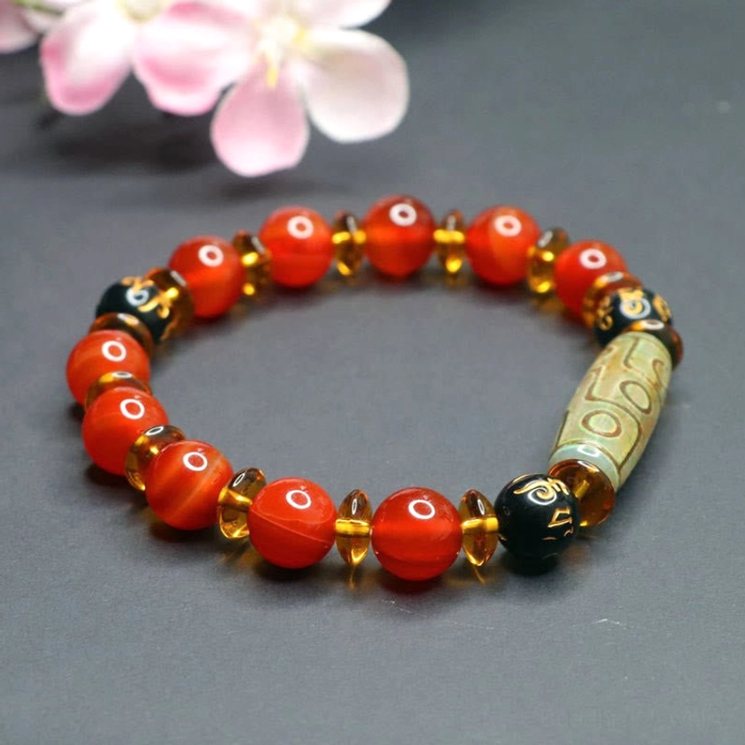 Red agate nine-eye dzi bead bracelet with black mantra spacers and gold accents - side view