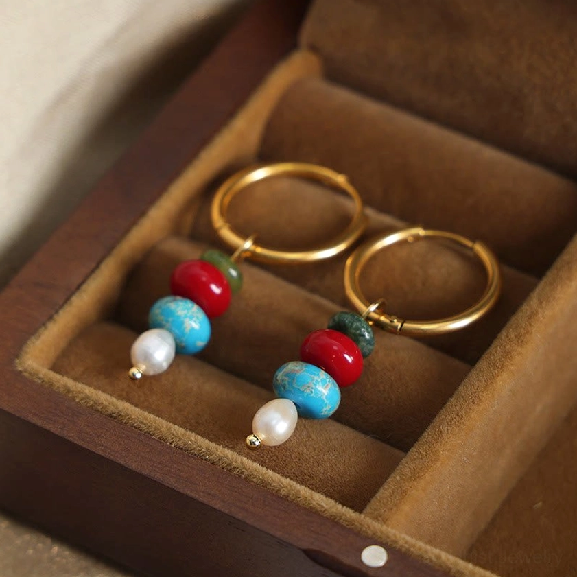 Pair of red agate Buddhist earrings in wooden jewelry box - top-down view of matching stone dangle earrings