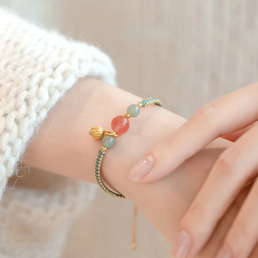 Red agate jade bracelet worn with cream knit sweater cuff cozy styling