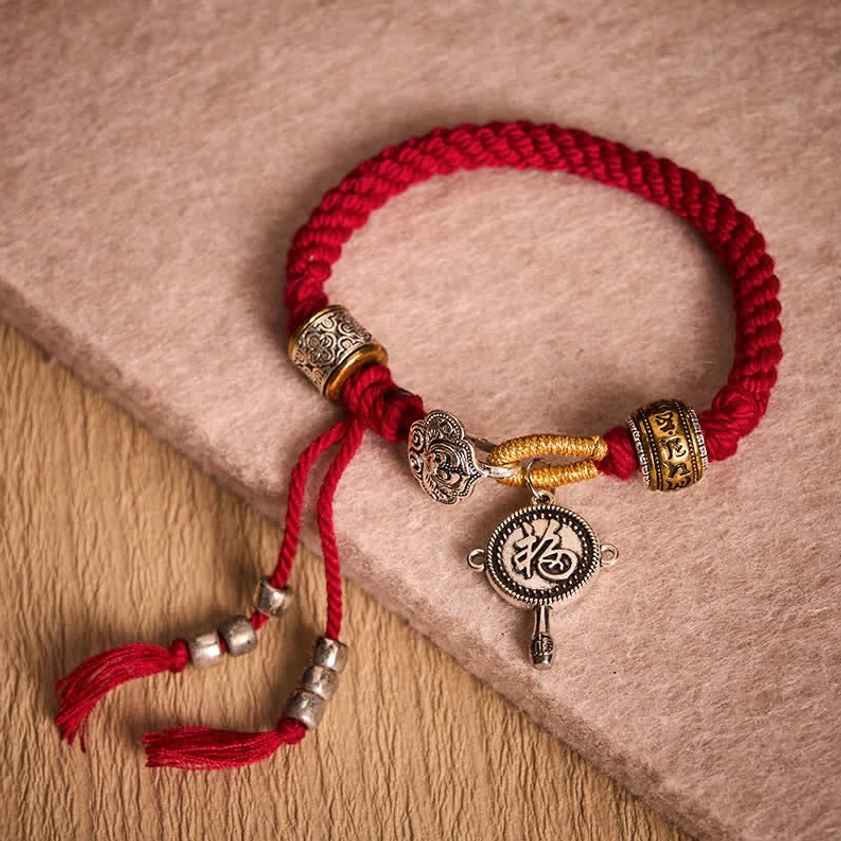 Red Braided Buddhist String Bracelet Close-up with Silver Charms
