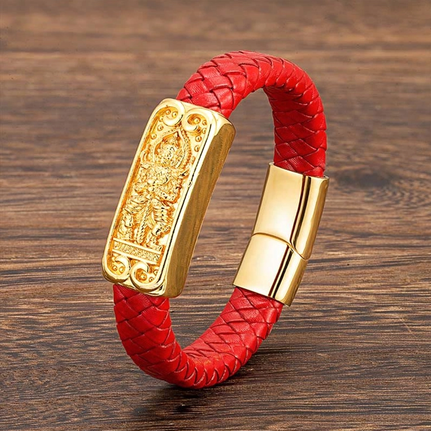 Red braided leather Buddhist bracelet with golden Buddha charm displayed on wooden surface