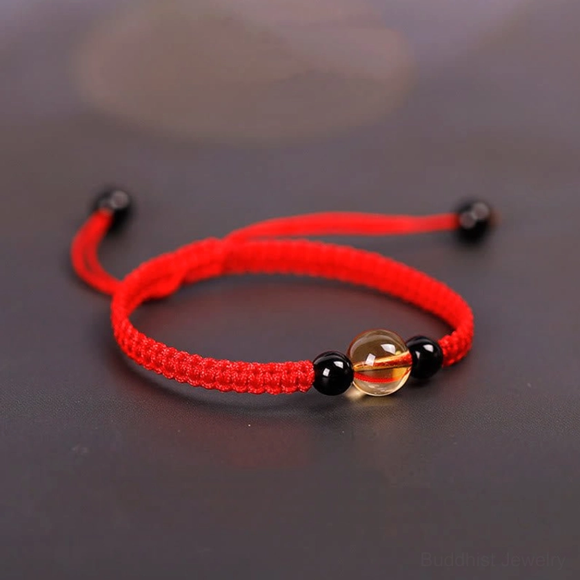 Red woven cord Buddhist bracelet with adjustable knot ends and citrine gemstone center bead