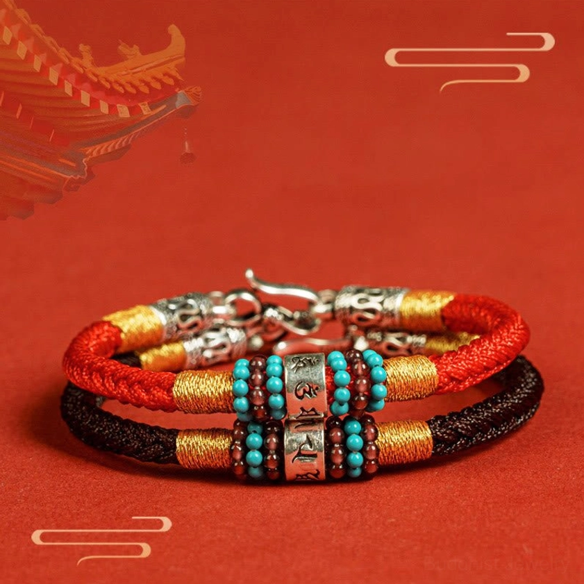 Red Buddhist string bracelet flat lay showing complete design with mantra bead and silver clasp