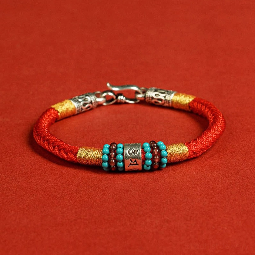 Red Buddhist string bracelet with engraved silver clasp, mantra bead, and turquoise accents