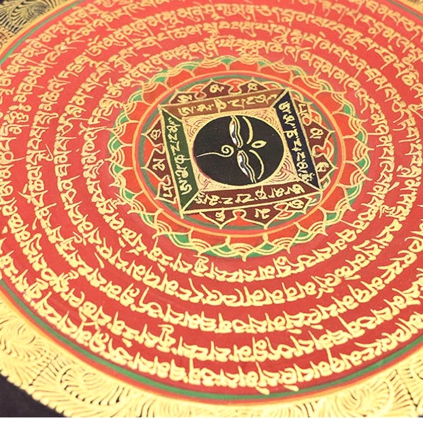 Macro photograph of red-toned Buddhist thangka featuring hand-painted gilded Tibetan mantra script with central square mandala design
