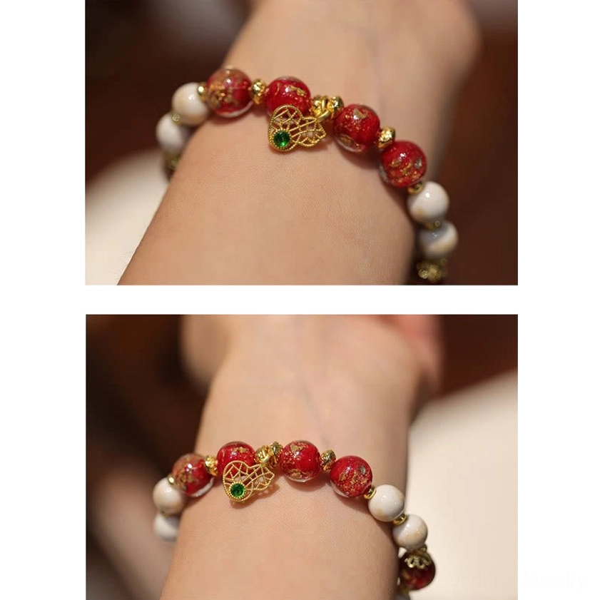Minimalist red beaded bracelet with gold bead details on octagonal white display tray