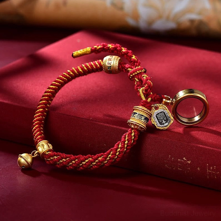 Red gold Buddhist string bracelet with Ghau prayer box amulet charm and protective metal bell for daily spiritual wear