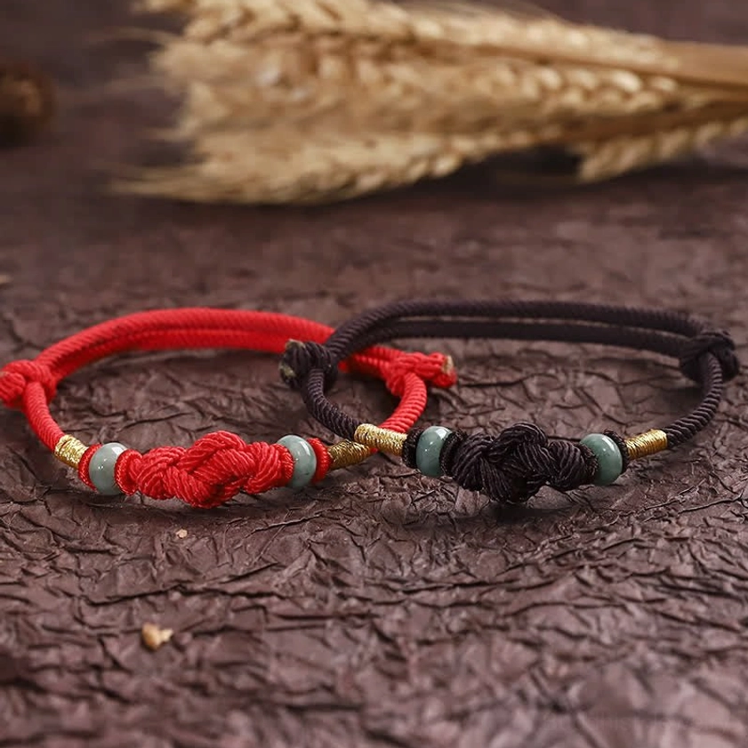 Two mixed-color Buddhist luck bracelets showing red and dark tones with matching knot design and jade accents
