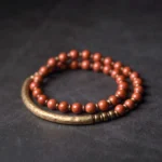 Red Jasper and Copper cuff couple bracelet set - flat lay showing two-piece stacked jewelry with reddish brown beads and antique bronze