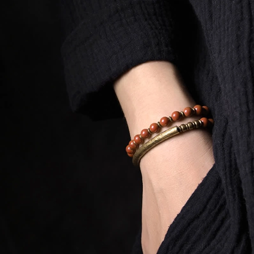 Worn Red Jasper crystal bracelet paired with smooth copper cuff on wrist - side profile close-up showing couple jewelry style