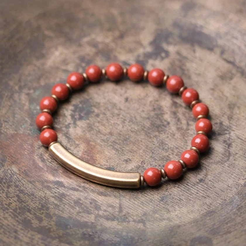 Red jasper and copper couple bracelet set with double-loop bead design - neatly arranged flat lay