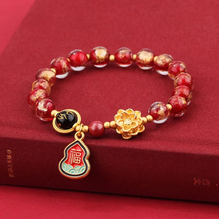Red crackle Liuli glass Buddhist bracelet with lotus charm, Fu character pendant, and sacred symbols