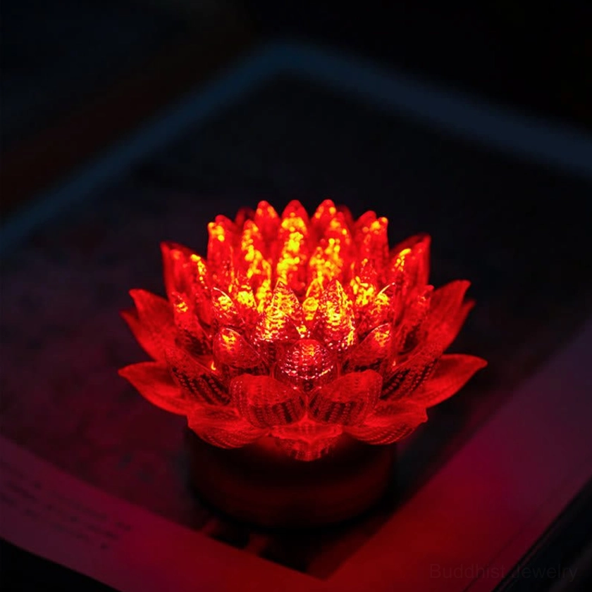 Red lotus night light glowing with deep crimson color, front close-up on dark background, layered petals