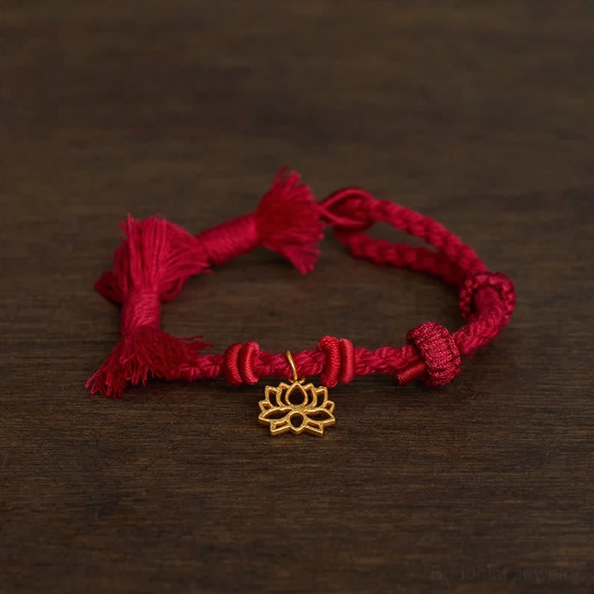 Red lotus bracelet oblique angle view displaying knotted braided cord construction and gold lotus charm detail
