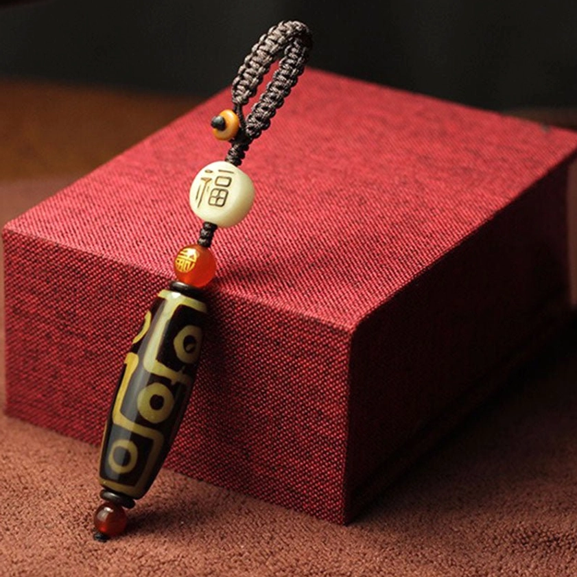 Nine-eye dzi bead keychain with red agate stone displaying nine circular symbols fu character charm and braided brown rope attachment