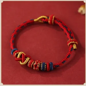 Red and gold peace knot Buddhist bracelet flat lay - handcrafted adjustable string design with protective spiritual symbolism
