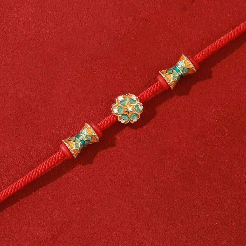 Red cord bracelet flat lay with three aligned sterling silver enamel beads on twisted rope
