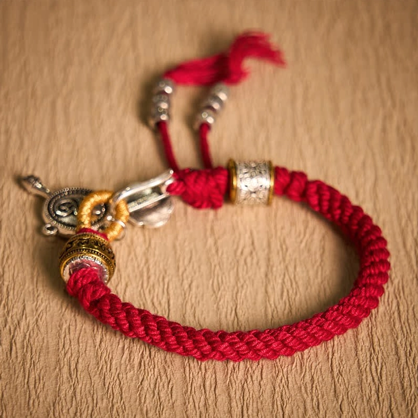 Red Buddhist Braided Rope Bracelet Flatlay Presentation on Wooden Surface