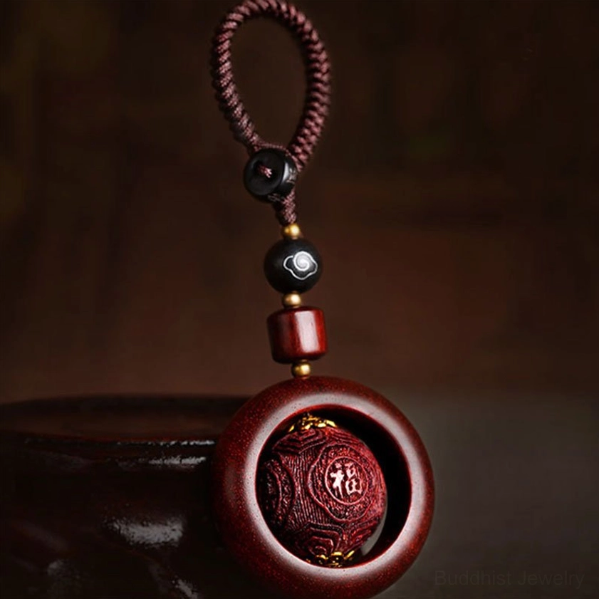Red sandalwood prayer keychain with auspicious symbol carving and ebony wood accent details