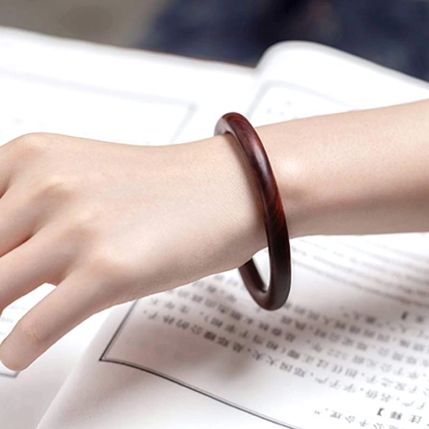 Red Sandalwood Buddhist Bangle side view on wrist - showing polished finish and natural wood grain pattern