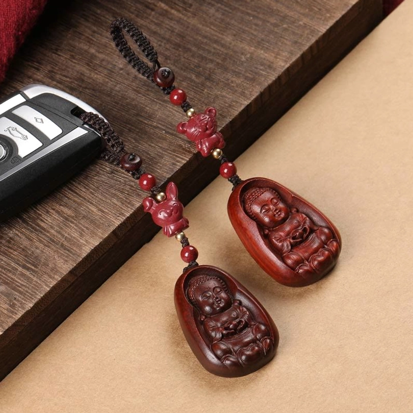 Multiple red sandalwood Buddha zodiac keychains overhead view showing distinct zodiac animal beads with dark wood texture