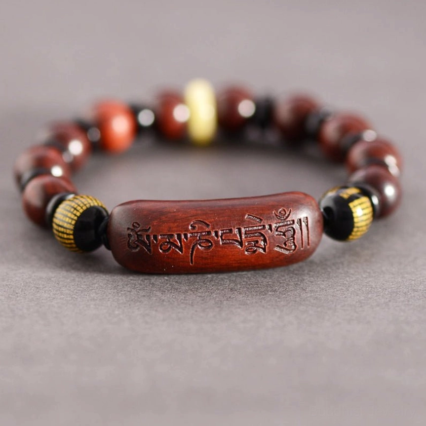 Buddhist prayer bracelet showing carved Sanskrit mantra detail from above