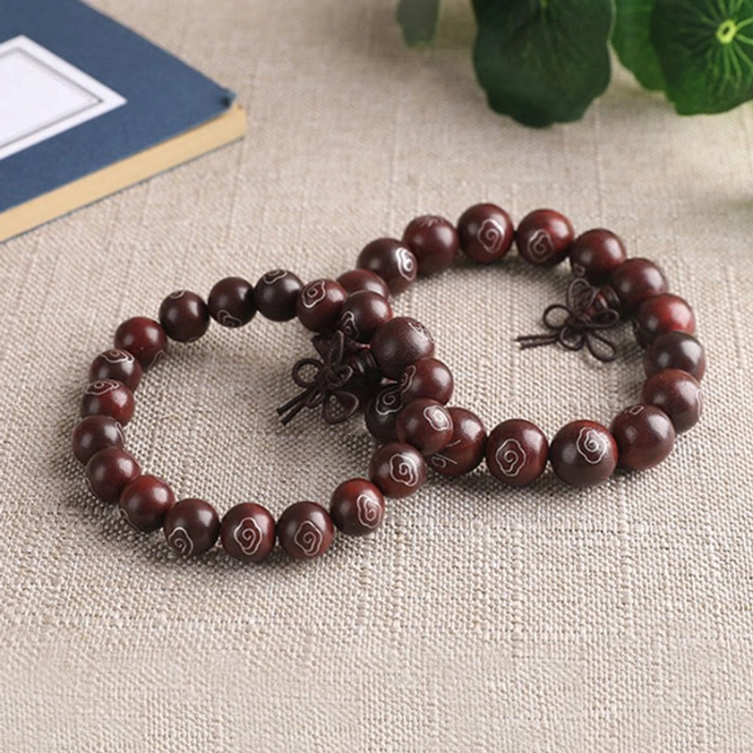 Pair of red sandalwood Buddhist bracelets with polished beads and silver inlaid sacred designs with foliage accent