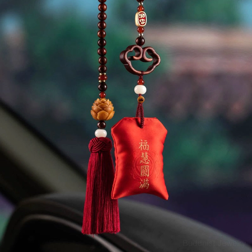 Car-mounted red sandalwood sachet with happiness blessing embroidery, red tassel, and beaded chain displayed in vehicle interior