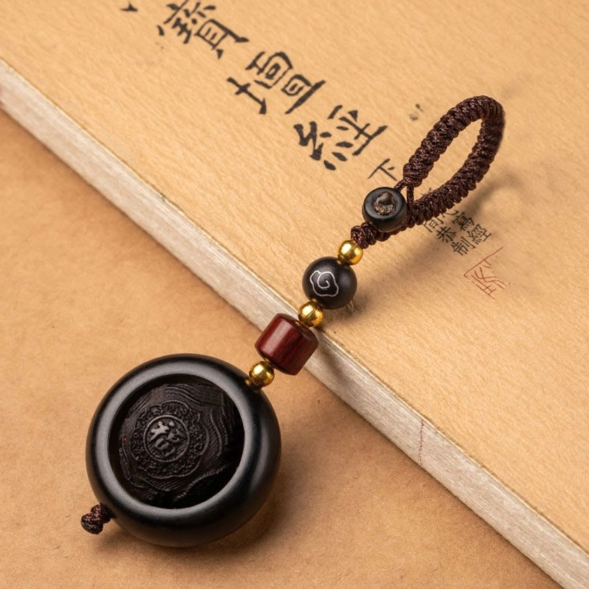 Red sandalwood and ebony rotating prayer keychain with auspicious symbol Buddhist design and black wood accents
