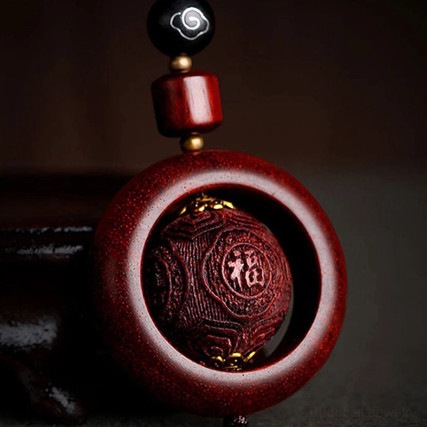 Hand-carved red sandalwood prayer keychain with fortune character engraving and lotus motif detail