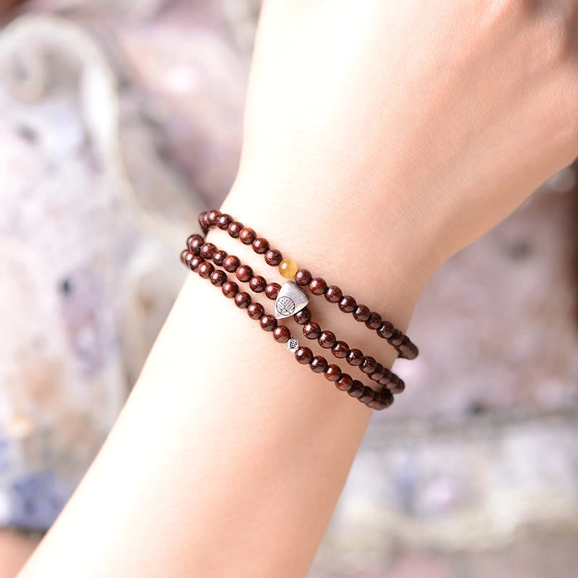 Wearable red sandalwood protection bracelet with Fu character on wrist close-up shot