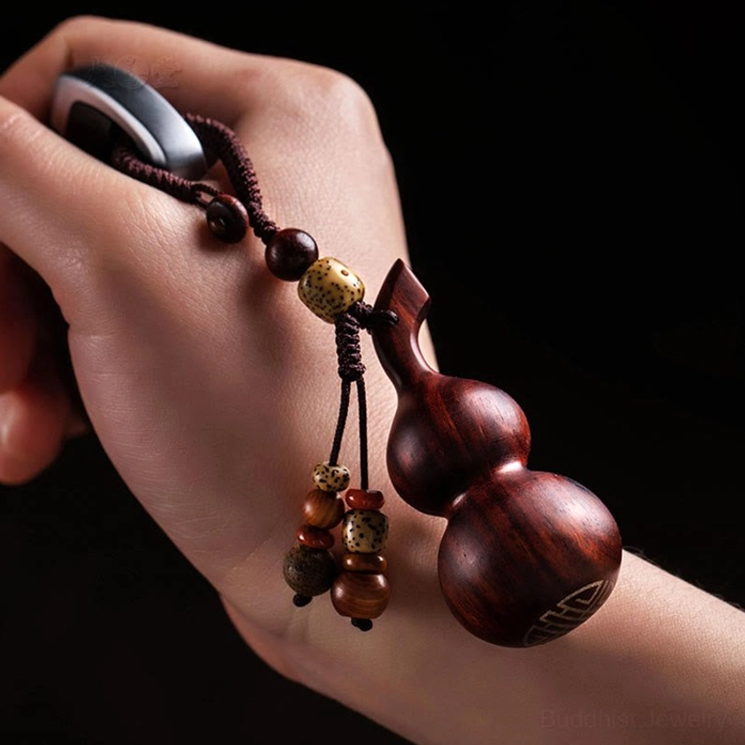 Red sandalwood gourd keychain paired with meditation or wellness accessories, representing inner peace and spiritual balance