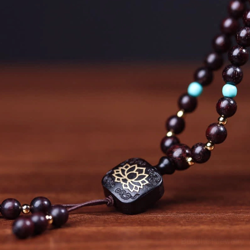 Close-up flat-lay view of 108 red sandalwood mala beads showing natural wood grain and mixed spacer beads