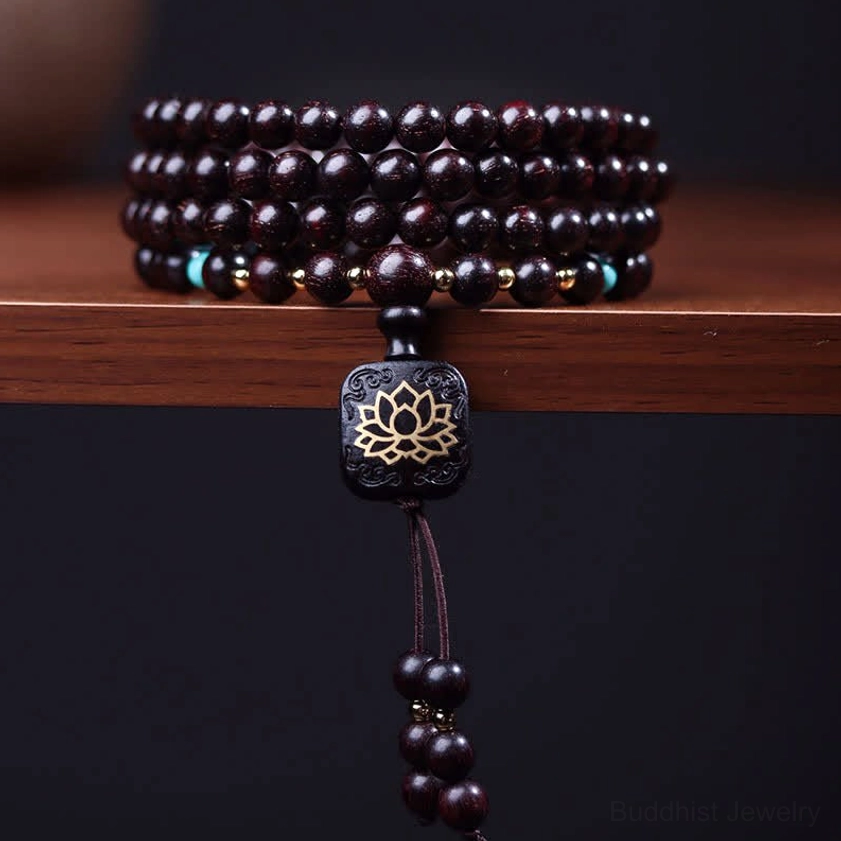 108 bead red sandalwood mala bracelet with square lotus pendant and wooden tassel, top-down studio display