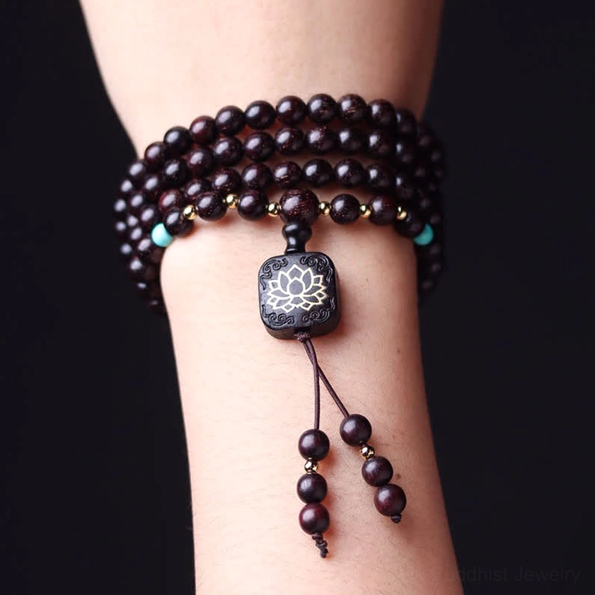 Side view of sandalwood mala bracelet on wrist demonstrating secure fit with lotus pendant and tassel