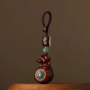 Red sandalwood money bag Buddhist charm with turquoise-inlaid rotatable front, braided cord attachment, and ping an peace bead - front view