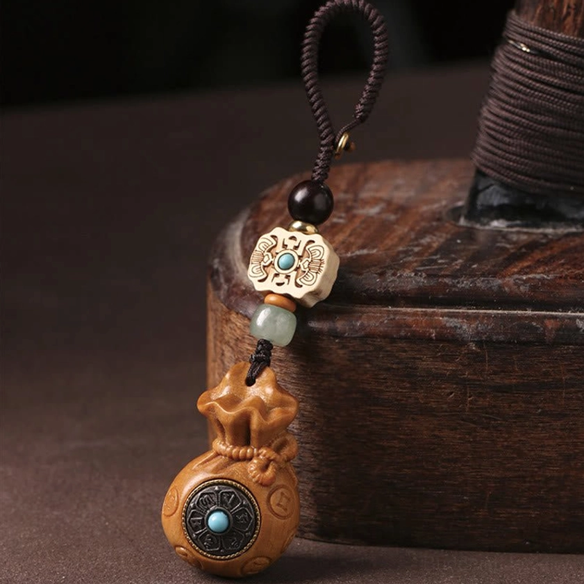 Red sandalwood Om Mani Padme Hum keychain with natural wood grain and protective turquoise stone