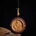 Red sandalwood Yellow Jambhala Buddhist pendant necklace with turquoise and red bead inlays, front close-up view
