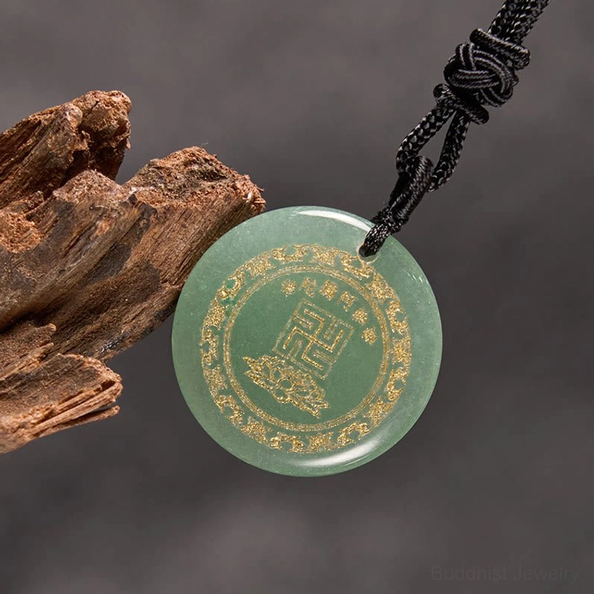 Red stone Buddhist pendant with braided necklace cord side angle on wooden surface