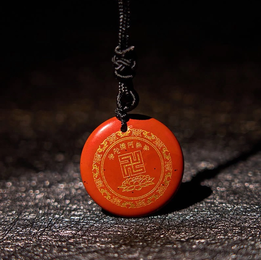 Red stone Buddhist pendant swastika symbol with braided cord overhead close-up view