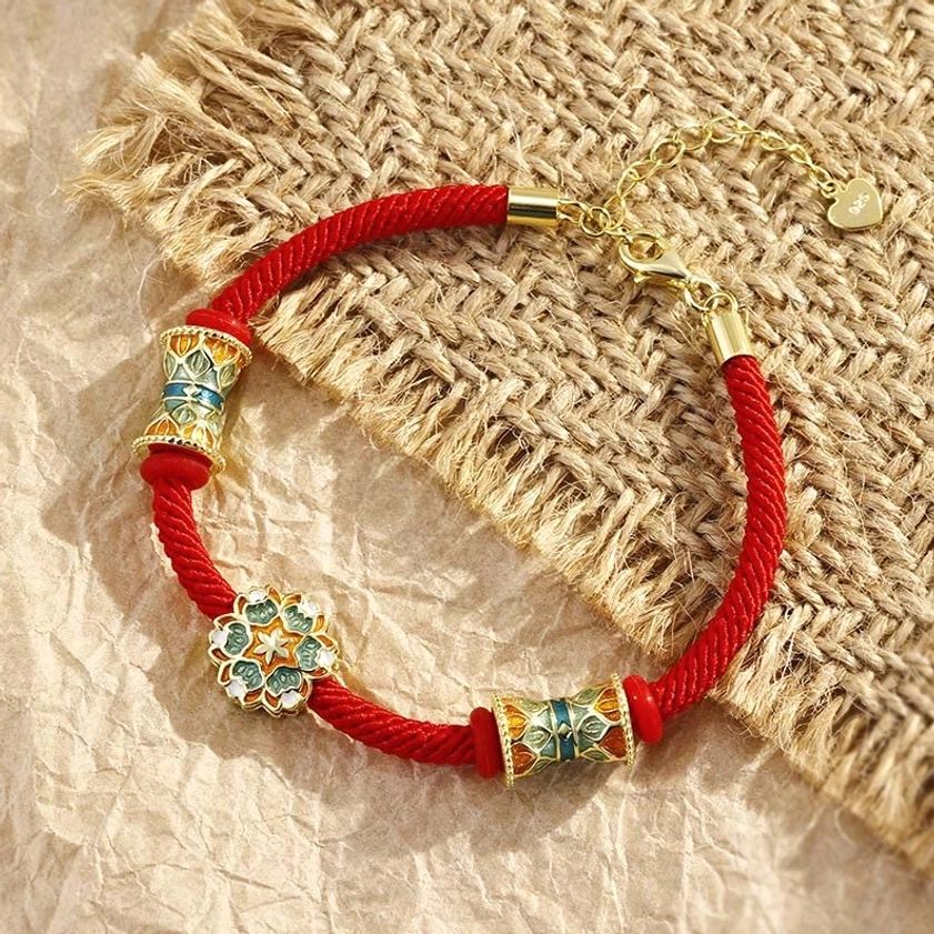 Buddhist red string bracelet with adjustable gold chain extender and decorative enamel beads flat lay