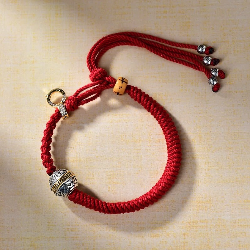 Buddhist red braided string bracelet with sterling silver Tara pendant, side perspective showing wooden and metal beads