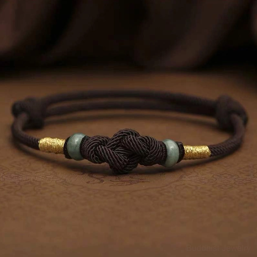 Red string jade bracelet showing natural material texture and color variation