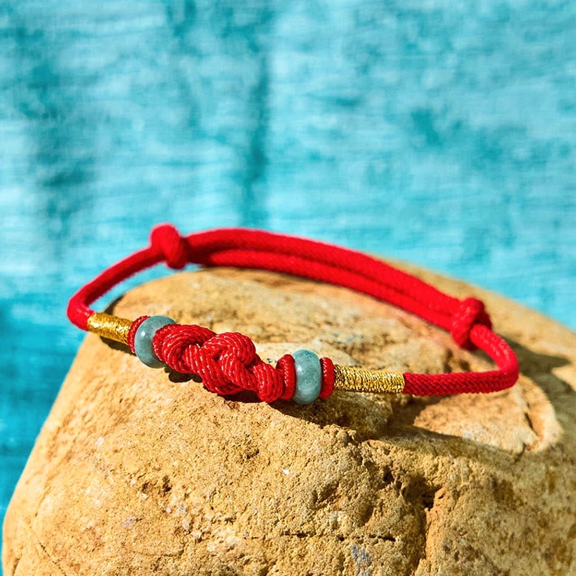 Buddhist red string jade bracelet side angle showing braided cord and jade bead details