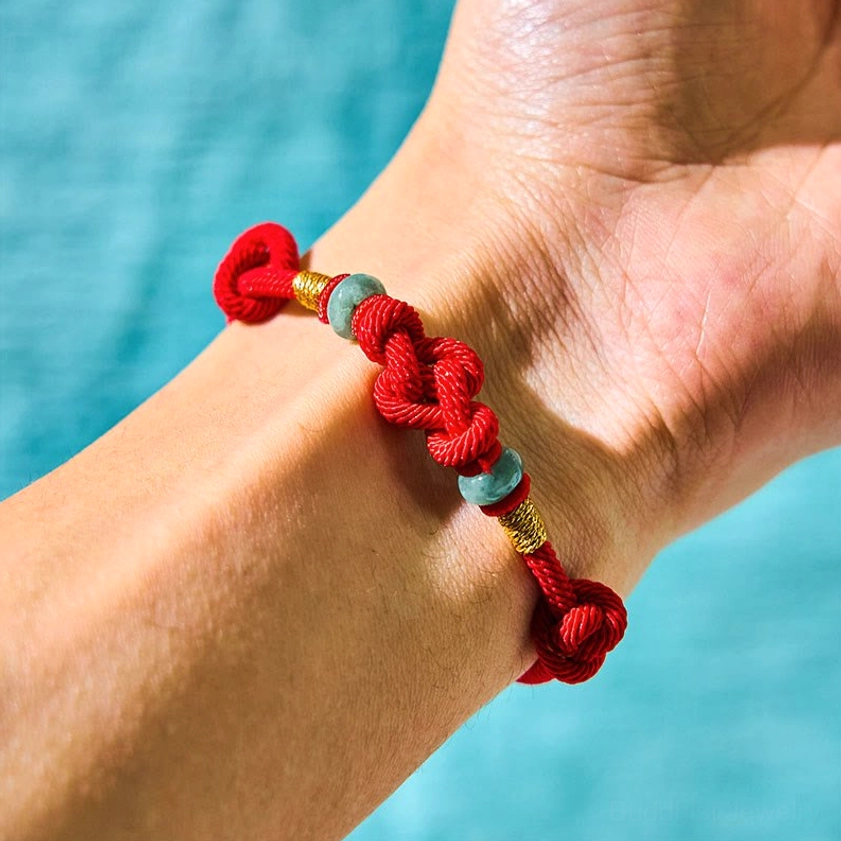 Red string jade couple bracelet worn on wrist showing adjustable fit and knot design
