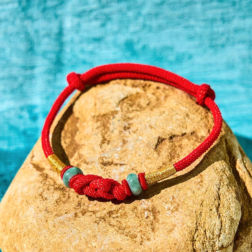 Red string jade couple bracelet top view with gold accents and braided knot design